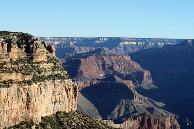 Panoramic view of rocky mountains against clear blue sky