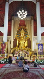 Statues in illuminated building at temple