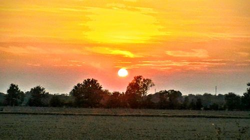 Scenic view of field against sky at sunset