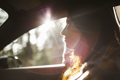 Smiling woman looking away in car during road trip
