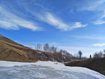 Scenic view of landscape against blue sky during winter