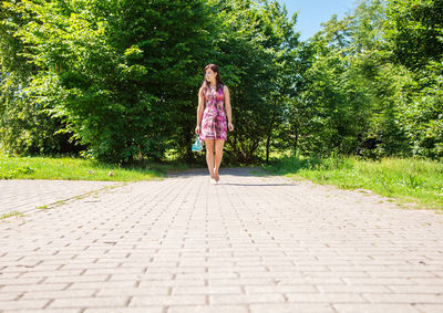Full length of woman walking on footpath