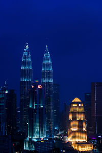 Illuminated buildings in city at night, petronas towers, kuala lumpur, malaysia