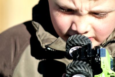 Close-up portrait of boy holding camera