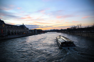 View of boat in river against cloudy sky