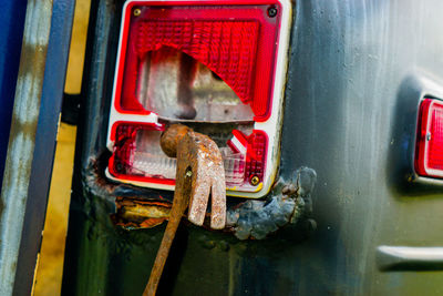 Close-up of hammer hanging on broken vehicle light