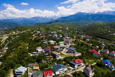 Aerial view of townscape and mountains against sky