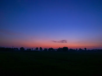 Scenic view of silhouette field against clear sky during sunset