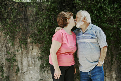 Full length of couple standing against plants