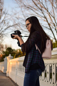 Woman photographing while standing on smart phone