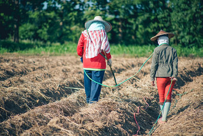 Rear view of man working on field