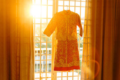 Close-up of clothes hanging on window at home