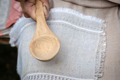 Midsection of woman holding wooden spoon