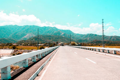 Road by mountains against sky