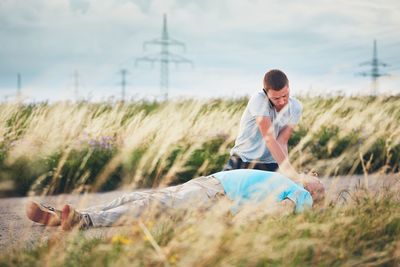 Full length of man lying on grass against sky