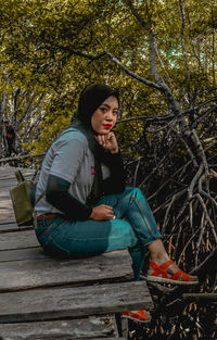 Full length of young woman sitting on bench