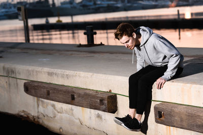 Side view of young man looking at railing