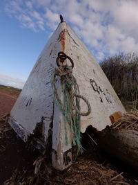 Close-up of text on wood against sky