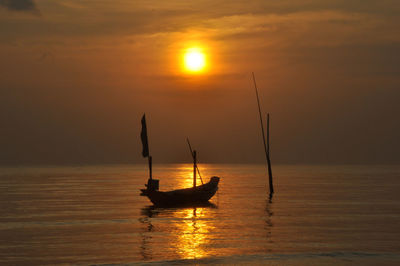 Silhouette boat in sea against sky during sunset