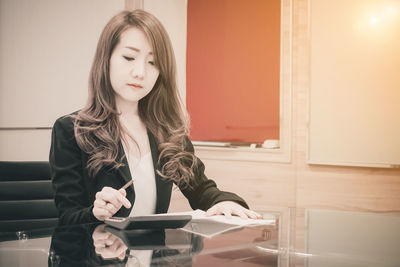 Businesswoman calculating at table in office