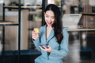 Portrait of young woman standing in cafe