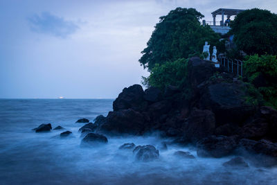 Rocks in sea against sky