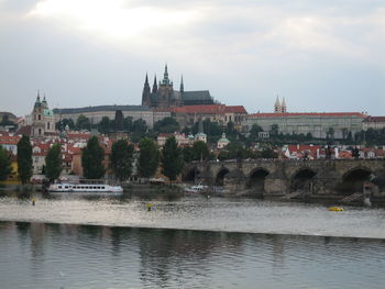 Arch bridge over river against buildings in city