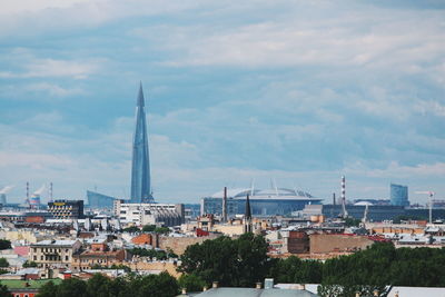 Buildings in city against cloudy sky