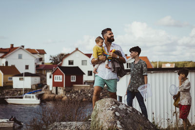 Father with children looking away while standing on archipelago