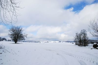 Scenic view of snow covered land against sky