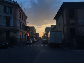 Cars on street in city against sky