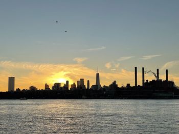 Silhouette buildings against sky during sunset