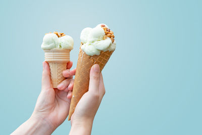 Woman hand holding vanilla ice cream, delicious desserts in summer, high-calorie food.