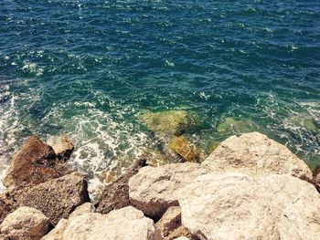 High angle view of rocks on sea shore