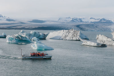 Boats in sea against sky during winter