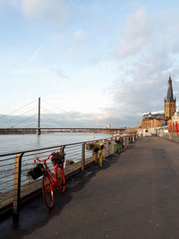 View of bridge over calm sea against cloudy sky