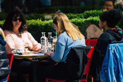 Rear view of people sitting on table