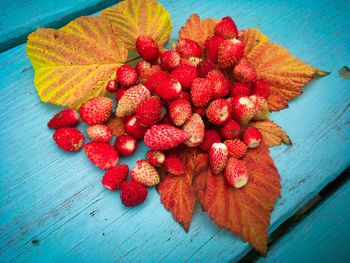 Close-up of strawberries and leaves on table during autumn