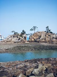 View of rocks against clear blue sky