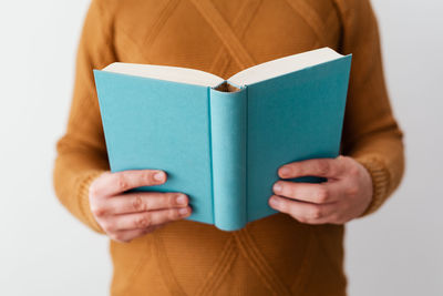 Midsection of man holding paper against white background