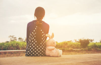 Full length of woman with toy against sky at sunset