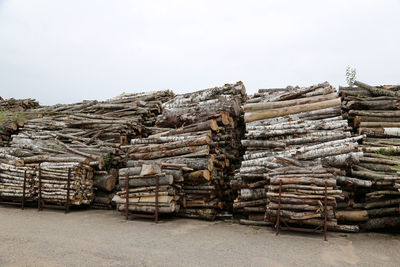 Stack of logs against sky