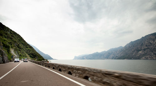 Surface level of road by sea against sky