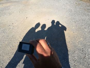 Shadow of man holding hands on sand