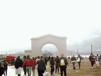 Group of people in front of historic building against sky