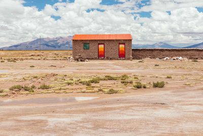 Built structure on field against sky