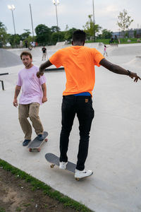 Rear view of boys standing on footpath