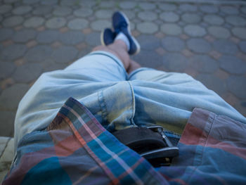 Low section of man relaxing on park bench