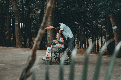 Rear view of couple on road amidst trees