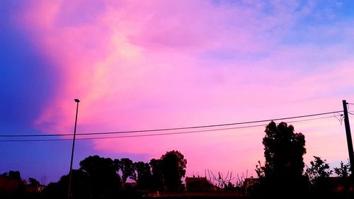 Low angle view of silhouette trees against sky at sunset